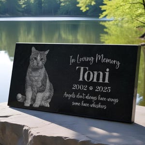 May include: Black granite pet memorial with a photo of a cat and the inscription "In Loving Memory Toni 2002-2025 Angels don't always have wings some have whiskers"
