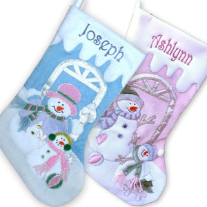 Peut inclure: Deux chaussettes de Noël personnalisées sur le thème du bonhomme de neige. La chaussette de gauche est bleue avec le nom "Joseph" brodé dessus. La chaussette de droite est rose avec le nom "Ashlynn" brodé dessus.