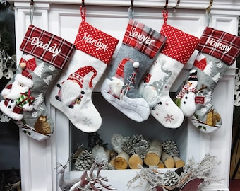 May include: Five red and white Christmas stockings with different names embroidered on them: Daddy, Martyn, Sawyer, Mommy. Each stocking has a different gnome or snowman design.