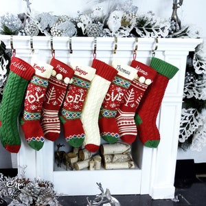 May include: Seven personalized Christmas stockings with red, green, and white knit patterns. The stockings are hung on a white fireplace mantel with the names "Addie", "Emily", "Papa", "Sawyer", "Thomas", "Mama" embroidered on them.