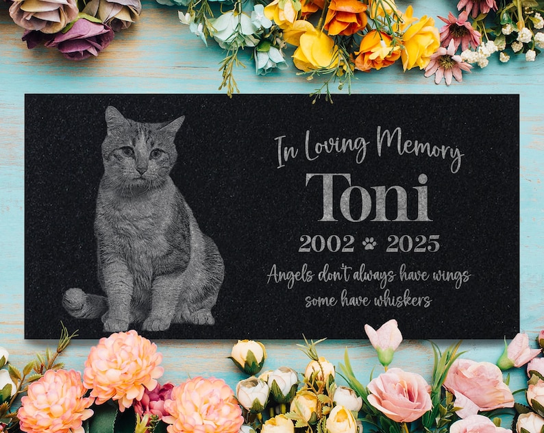 May include: Black granite pet memorial with a gray cat silhouette, the text "In Loving Memory Toni 2002 2025 Angels don't always have wings some have whiskers"