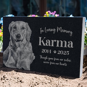 May include: Black granite pet memorial with a photo of a golden retriever. The inscription reads "In Loving Memory Karma 2014 2025 Though gone from our sides, never from our hearts."