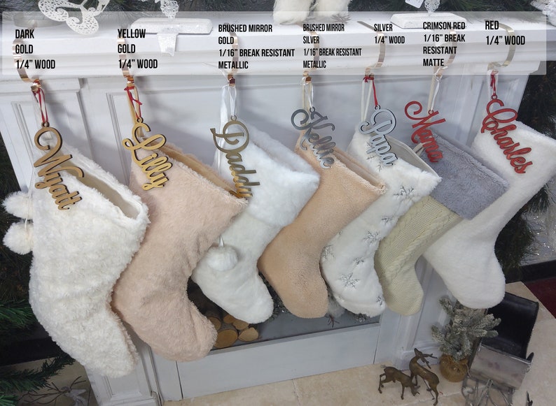 May include: Six personalized Christmas stockings with names "Man", "Lilly", "Daddy", "Kelle", "Papa", and "Charles" hanging on a white fireplace mantel. The stockings are made of white and beige faux fur and have pom-poms at the top.