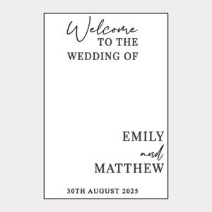 May include: A rectangular wedding sign with black text on a white background. The sign reads "Welcome to the Wedding of Emily and Matthew" with the date "30th August 2025" at the bottom. The text is in a stylish, elegant font.