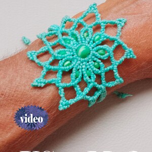 May include: A turquoise lace bracelet with a floral design and a central bead. The bracelet is worn on a wrist. The image also includes the word "video" and the text "USewMe2".