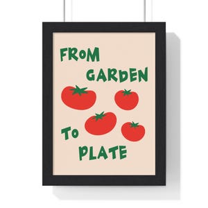 May include: Framed art print with a beige background, four red tomatoes with green stems, and green text reading "FROM GARDEN TO PLATE". The artwork is presented in a black frame, suitable for kitchen or dining room decor.