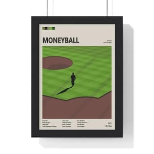 May include: Framed "Moneyball" film poster. The poster shows a minimalist design of a baseball field with a silhouetted figure walking across the green grass. The title "Moneyball" is at the top, with the director's name and cast credits below.