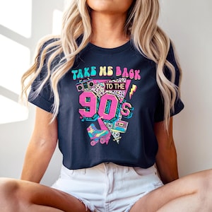 May include: Navy blue t-shirt with a colorful graphic design. The design features the text "TAKE ME BACK TO THE 90'S" with a boombox, roller skate, and cassette tape. The graphic is in pink, teal, yellow, and white.