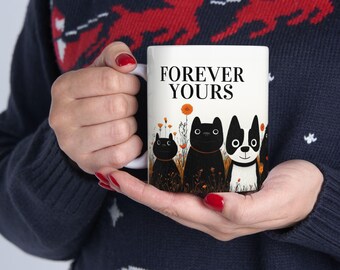 Könnte beinhalten: Weiße Keramiktasse mit Schwarzweißillustrationen von Katzen und einem Hund. Die Tasse trägt den Schriftzug "FOREVER YOURS" in Schwarz.