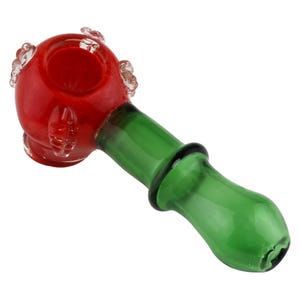 Op de afbeelding: Een rode en groene glazen pijp met een ronde kom en een decoratief ontwerp. De kom is rood met heldere glazen accenten en de steel is groen.