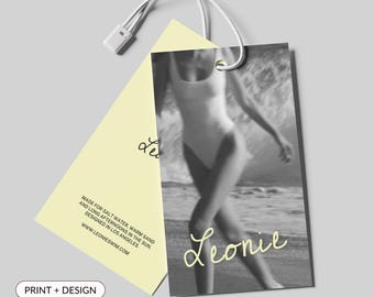 May include: Two rectangular paper hang tags attached by a white plastic fastener. One tag is pale yellow with black text reading Leonie, Made for salt water, warm sand and long afternoons in the sun. Designed in Los Angeles. www.leonieswim.com.