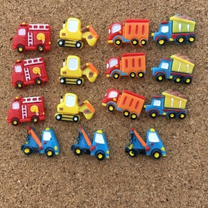 May include: A set of 12 colorful toy vehicle push pins, including a fire truck, a dump truck, a construction vehicle, and a tow truck. The push pins are made of plastic and have a variety of colors, including red, yellow, blue, and orange.