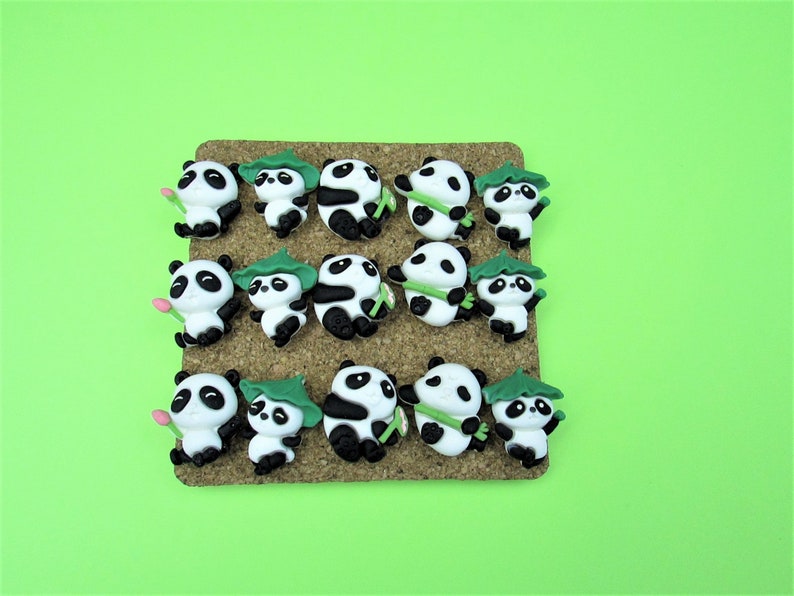 15 Pandas playing with bamboo. Some are wearing leaf hats and holding bamboo and bamboo shoots. Each panda is about 1 inch tall. They come in a metal box with window.