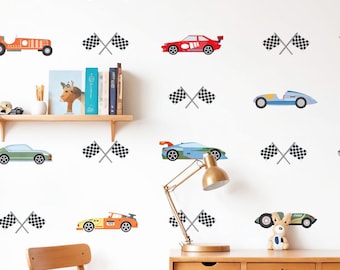May include: A white wall decorated with colorful race car decals and checkered flags. The cars are in various colors, including red, yellow, blue, and green. A wooden desk, chair, and shelf are also visible.