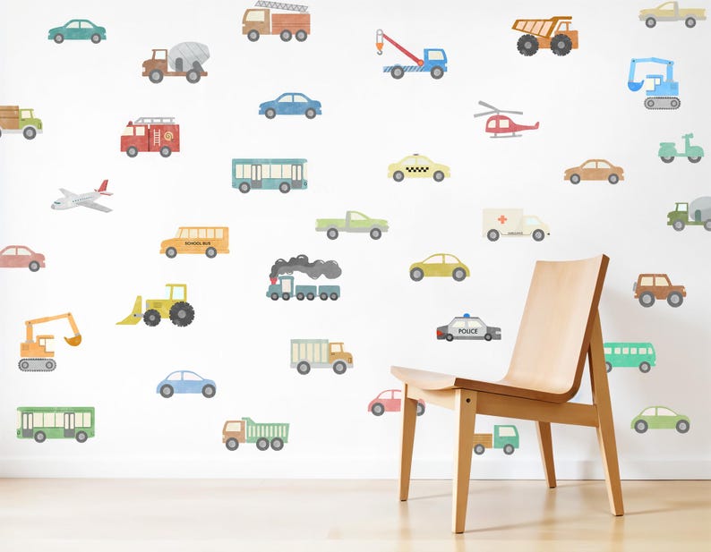 May include: A white wall decorated with colourful cartoon vehicle decals, including a school bus, police car, ambulance, fire truck, excavator, aeroplane, and a helicopter. There is a wooden chair in front of the wall.
