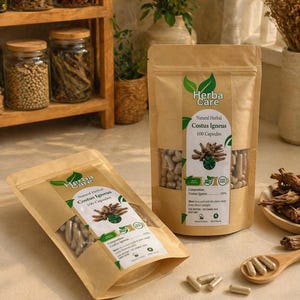 May include: Two brown paper pouches of "Herba Care Natural Herbal Costus Igneus 100 Capsules" are displayed. The pouches are filled with capsules. The image also shows a wooden shelf with jars and a wooden spoon with capsules.