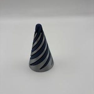 May include: A silver-colored ring holder in the shape of a cone with dark blue, curved stripes. The ring holder is on a white background.