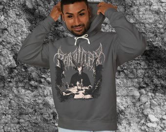 Könnte beinhalten: Grauer Kapuzenpullover mit einem grafischen Aufdruck, der eine gehörnte Figur an einem Tisch mit Kerzen und zwei Figuren zeigt. Das Wort "PARADISE" ist in einer gotischen Schriftart über dem zentralen Bild aufgedruckt.