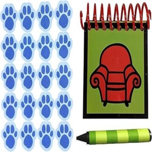 Puede incluir: Un conjunto de artículos de la serie infantil Blue's Clues. Incluye pegatinas azules con huellas de patas, un bloc de notas con espiral con un sillón rojo sobre un fondo verde y un crayón verde y amarillo.