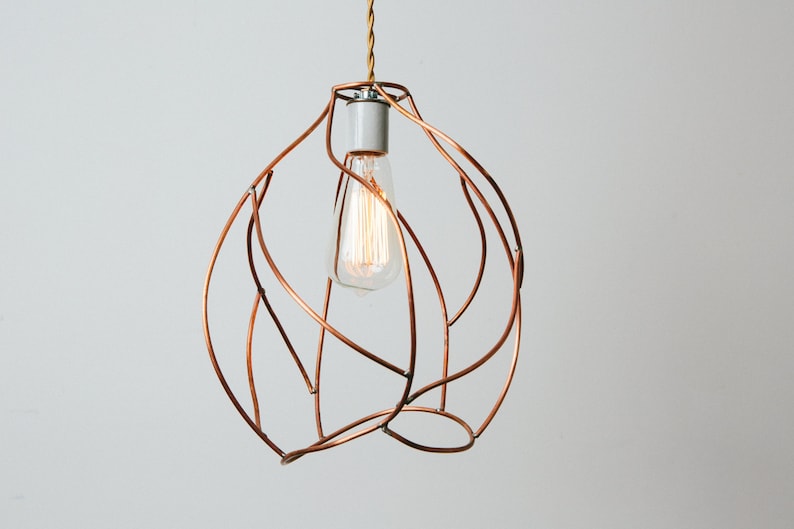 May include: A copper wire pendant light fixture with a single light bulb. The light fixture is shaped like a sphere with a swirling, organic design.