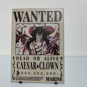 May include: A wanted poster featuring a cartoon image of Caesar Clown from the anime One Piece. The poster is brown with black text and a red and white background. The text reads "WANTED DEAD OR ALIVE CAESAR CLOWN £300,000,000- MARINE".
