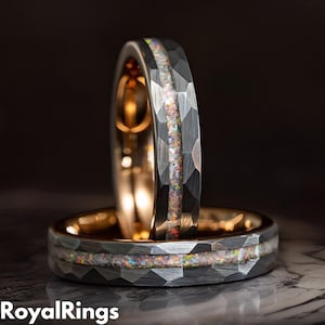 May include: Two silver and black wedding bands with a hammered finish and a thin line of iridescent opal inlay.