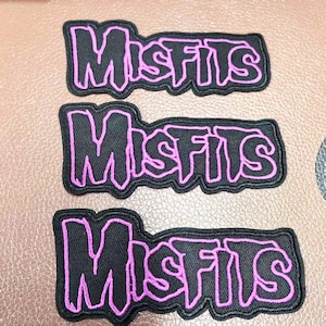 May include: Three black fabric patches with the word "Misfits" in pink outlined lettering.