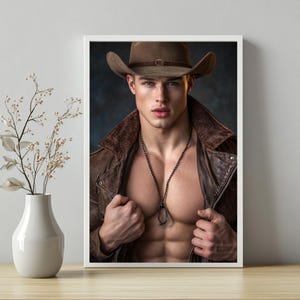 Puede incluir: Impresión enmarcada que muestra a un hombre con sombrero de vaquero y chaqueta de cuero marrón. Lleva un collar y tiene un físico musculoso. La imagen está sobre un fondo oscuro, con un jarrón y una planta en primer plano.