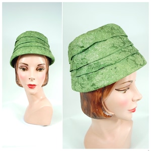May include: A green, floral patterned hat with a wide brim and a pleated crown.