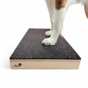 May include: A dog grooming platform with a black surface and red speckles. The platform has a light wood frame and the text "Set Groom" with a paw print logo. A dog stands on the platform.