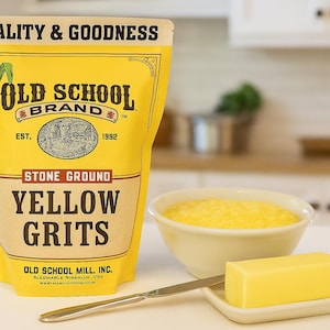 May include: A yellow bag of "Old School Brand" stone-ground yellow grits, a white bowl of grits, a pat of butter on a small white dish, and a butter knife. The bag has a corn graphic and the text "Quality & Goodness".