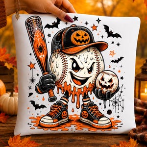 May include: A white square throw pillow featuring a cartoon baseball character wearing a pumpkin-themed baseball cap and sneakers, holding a baseball bat and a smaller jack-o'-lantern baseball, surrounded by bats, stars, and spiderwebs.