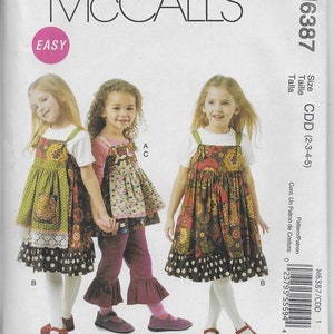 May include: A sewing pattern for a girls' dress with a ruffled skirt and a bib top. The pattern is from McCall's and is labeled "Easy". The pattern is for sizes 2-3-4-5.