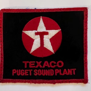 May include: Red and white Texaco star logo patch with the text "Texaco Puget Sound Plant" on a black background.