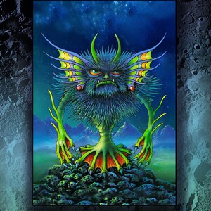 May include: A vibrant illustration of a creature with a stern expression, featuring green, yellow, and blue hues. The artwork includes the text "Stroppo" and a circular logo with the words "Moon Aliens". The phrase "One small stepladder for Moonkind" is also present.