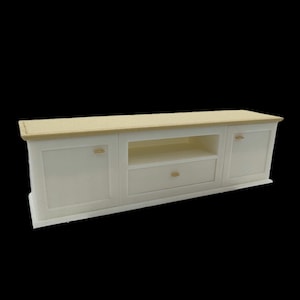May include: A white TV stand with a light wood top. The stand has two doors, a drawer, and an open shelf. The doors and drawer have small, round, gold-colored knobs. The stand is approximately 60 inches long.