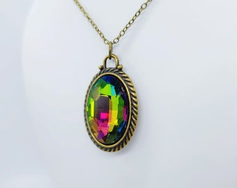 May include: A gold-toned necklace with a large iridescent oval gemstone pendant. The pendant is set in a detailed, ornate frame.