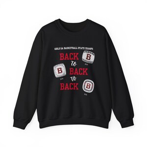 May include: Black sweatshirt with the text "GIRLS SA BASKETBALL STATE CHAMPS BACK TO BACK TO BACK" and three championship rings with the year 2021, 2024, and 2025.