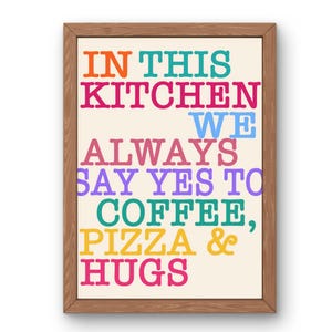 Könnte beinhalten: Gerahmter Küchen-Wandkunstdruck mit dem Text "IN THIS KITCHEN WE ALWAYS SAY YES TO COFFEE, PIZZA & HUGS" in verschiedenen leuchtenden Farben. Der Rahmen ist aus Holz.