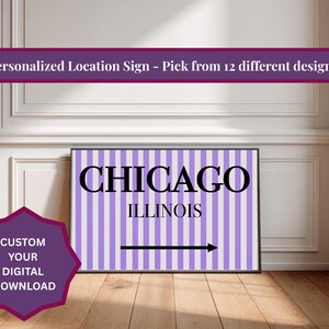 Könnte beinhalten: Ein gerahmtes Schild mit dem Wort "CHICAGO" in großen schwarzen Buchstaben über "ILLINOIS" auf einem gestreiften lila und weißen Hintergrund. Ein schwarzer Pfeil zeigt nach rechts. Das Schild wird auf einem Holzboden angezeigt.