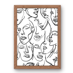 Könnte beinhalten: Ein gerahmter Kunstdruck mit einer Sammlung von Schwarz-Weiß-Linienzeichnungen von Gesichtern. Das Kunstwerk wird in einem Naturholzrahmen präsentiert, wodurch eine minimalistische und moderne Ästhetik entsteht. Die Gesichter sind mit einfachen, durchgehenden Linien dargestellt.