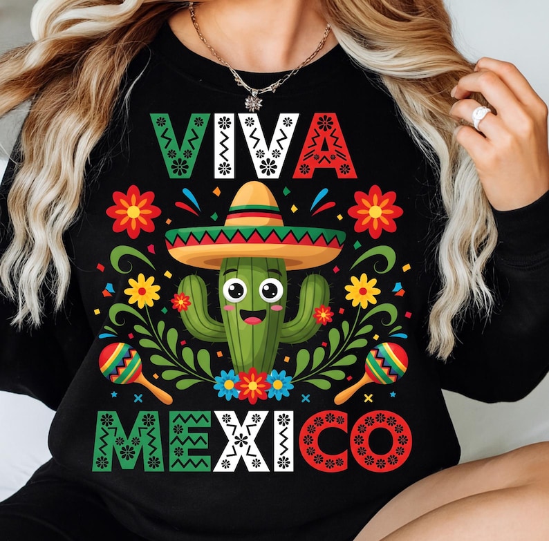 Op de afbeelding: Zwart sweatshirt met een kleurrijk "VIVA MEXICO" ontwerp. De afbeelding toont een lachende cactus met een sombrero, omringd door bloemen en maracas. Het ontwerp gebruikt groen, rood, geel en blauw.