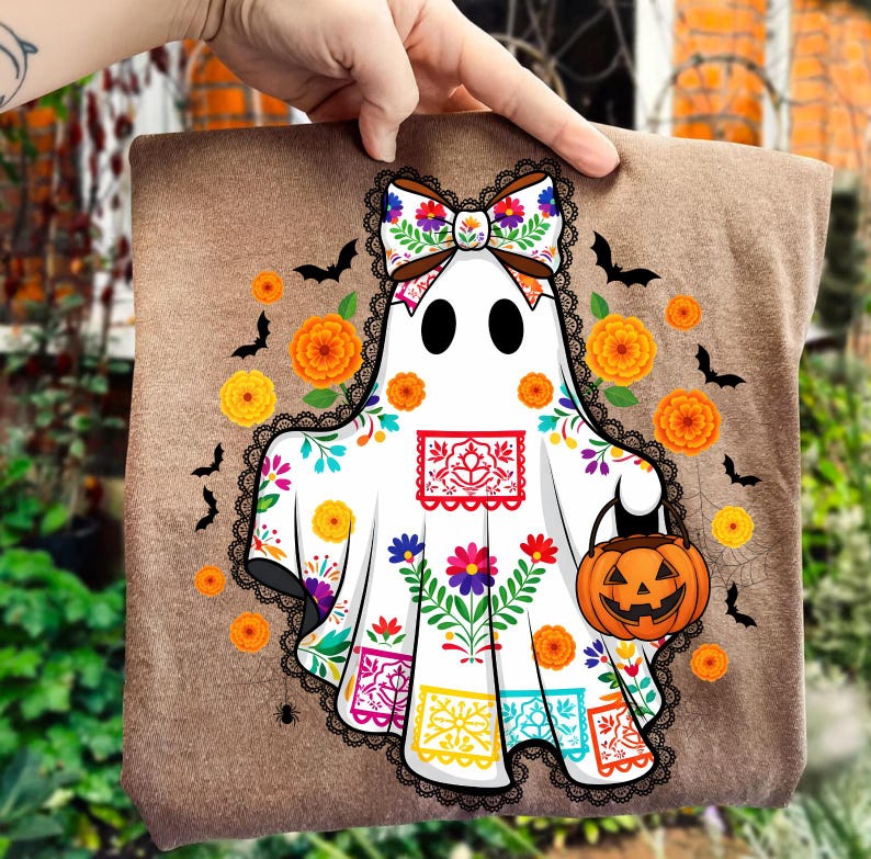 May include: A brown Halloween-themed tote bag featuring a white ghost with a colorful floral design, a bow, and a jack-o'-lantern. Black bats and orange flowers decorate the background. The ghost is holding a pumpkin.