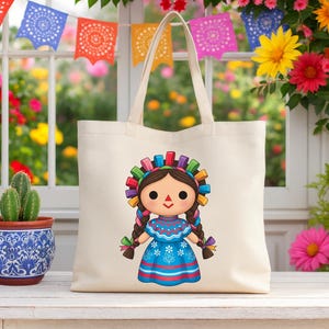 K&ouml;nnte beinhalten: Eine cremefarbene Tragetasche mit einem Cartoon-Puppe-Design. Die Puppe hat braune Z&ouml;pfe, ein blaues Kleid und ein farbenfrohes Stirnband. Der Hintergrund umfasst bunte Blumen und dekorative Papierflaggen.
