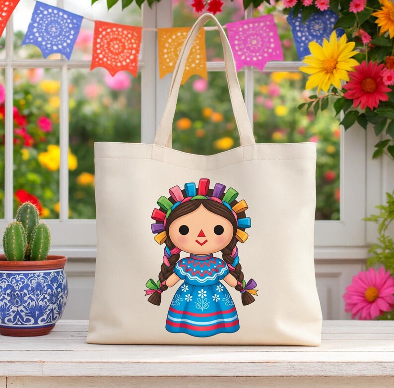 K&ouml;nnte beinhalten: Eine cremefarbene Tragetasche mit einem Cartoon-Puppe-Design. Die Puppe hat braune Z&ouml;pfe, ein blaues Kleid und ein farbenfrohes Stirnband. Der Hintergrund umfasst bunte Blumen und dekorative Papierflaggen.