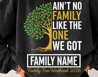 May include: A charcoal black crewneck sweatshirt featuring a graphic of a tree with green leaves and a gold trunk. The text reads AIN'T NO FAMILY LIKE THE ONE WE GOT, FAMILY NAME, and Family Fun Weekend 2026 in white and gold lettering.