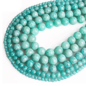 May include: A strand of round, green aventurine beads of varying sizes. The beads are smooth and polished, with a subtle shimmer.
