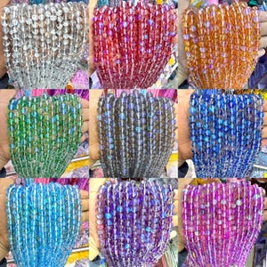 May include: Assortment of iridescent glass beads in various colors, including clear, red, green, blue, purple, and pink. The beads are round and have a smooth, polished finish.