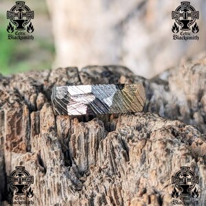 May include: A silver ring with a hammered finish. The ring is made of meteorite metal and has a unique pattern.
