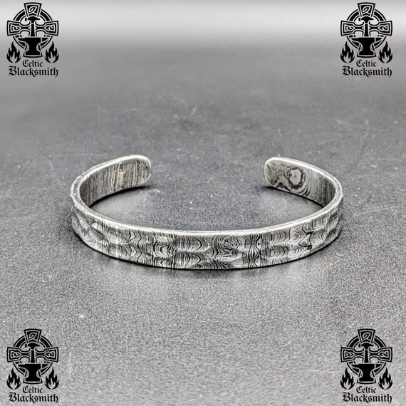 Actually hand-forged Damascus steel — the hammered texture and layered metal patterns make each cuff genuinely one-of-a-kind in a way no factory can replicate.